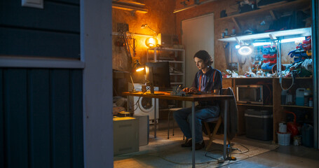 Wide Shot Of Caucasian Male Software Engineer Coding on Old Desktop Computer In Retro Garage In The...