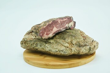 Dried meat without a shell in spices lies on a wooden board. The product is ready to use. White background.