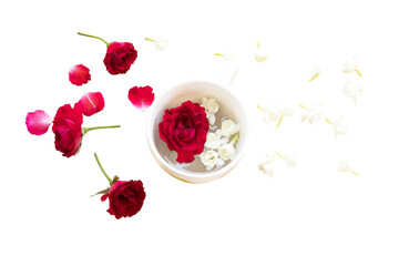 red rose, jasmine flowers float on water in cup arrangement flat lay postcard style 
