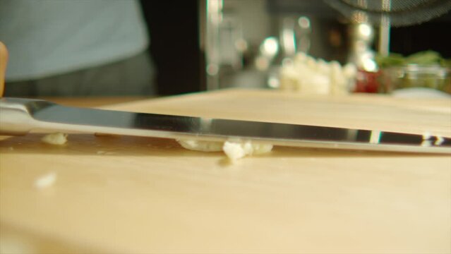 4k Slow Motion close up knife crush and smash garlic on cutting board