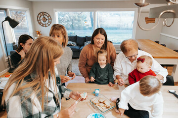 Large family enjoys decorating sugar cookies, kitchen joy
