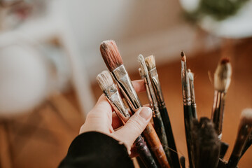 girls hand sorting paint brushes in the art studio