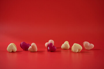 flat lay heart shape of macarons on red background