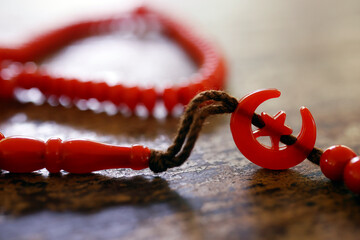 Red tasbih ( muslim prayer beads ) with star and crescent. Symbol of Islam.