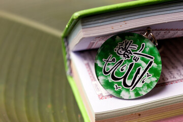 The Quran, holy book of Muslims from God with Allah monogram. Symbols of islam.
