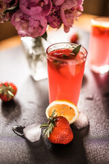 Strawberry soda delight. A sweet and tangy summer drink served in a glass with ice cubes. pink color and fresh strawberry slices