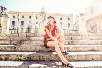 Young smiling tourist woman relaxing while exploring the city.