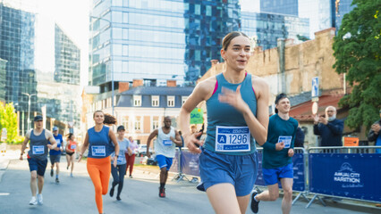 Diverse Group of People Running a Marathon in a City During the Day. Active and Fit Smiling Female Runner Competing to Reach the Finish Line, Supported by Friends and Family