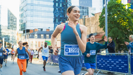 Diverse Group of People Running a Marathon in a City During the Day. Active and Fit Smiling Female...