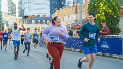 Diverse Group of People Running a Marathon in a City During the Day. Smiling Plus Size Female...