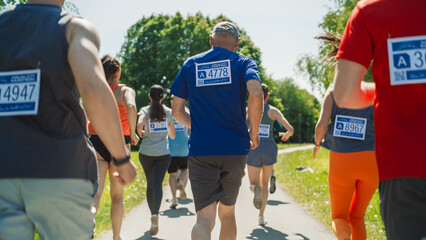 Back View: Portrait of a Diverse Group of People Participating in a Marathon and Running Through a...
