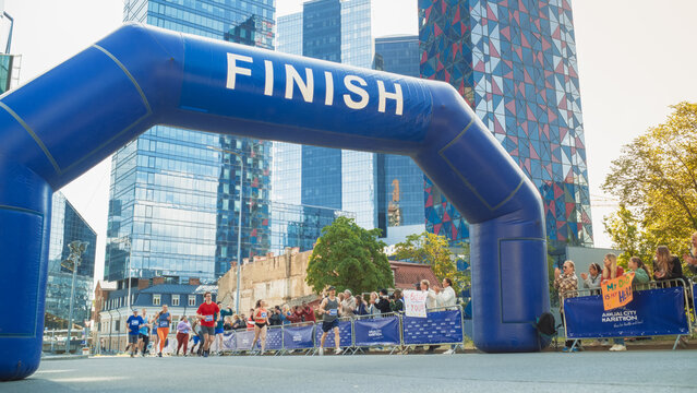 Smiling Group of People Participating in a City Marathon. Wide Shot of Diverse Race Runners Reaching the Finish Line, Celebrating Their Victory and Achieving their Goal