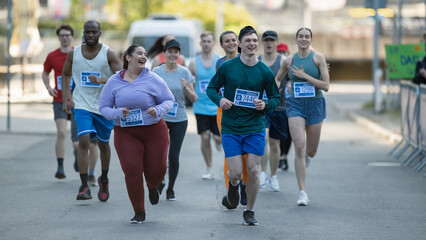 Group of Diverse People Running in a Marathon with the Cheers of their Loved Ones and Supporters in...