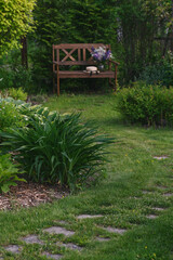 rustic summer cottage garden view with wooden bench.