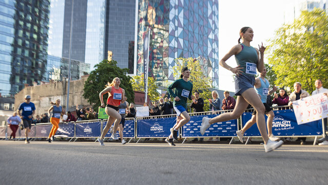 Diverse Group of People Running a Marathon in a City During the Day. Family and Friends Supporting and Cheering Male and Female Runners Competing to Reach the Finish Line