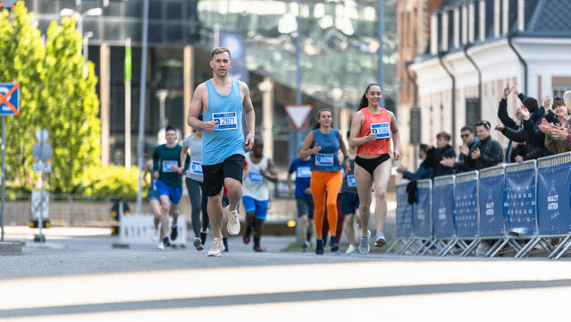 Smiling Group of People Participating in a City Marathon. Diverse Race Runners Reaching the Finish Line, Celebrating Their Victory and Achieving their Goal