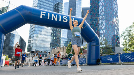 Portrait of Happy Female Runner Participating in a Marathon. Athletic Female Crossing the Finish...