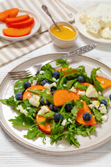 arugula persimmon cheese berries salad, top view
