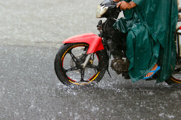Season Monsoon. Heavy rain and water logging on road.  Motor bike.