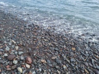 
Jeju Island beach with round basalt rocks.