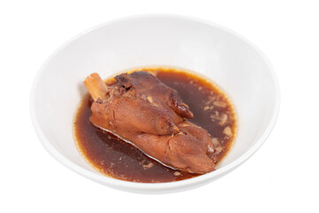 Pork knuckle or German pork hocks with vegetable and fruit served with sauce on chopping board and on wooden table.