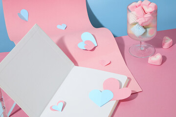 Transparent wine glass filled with lots of marshmallows featured with a pink paper and an opening...