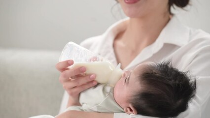 no-face video of a woman feeding her baby