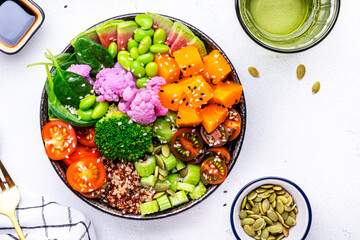 Vegan buddha bowl with pumpkin, quinoa, tomatoes, spinach, celery, edamame, tofu, cauliflower,...