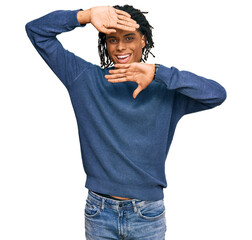 Young african american man wearing casual winter sweater smiling cheerful playing peek a boo with...