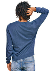 Young african american man wearing casual winter sweater backwards thinking about doubt with hand on head