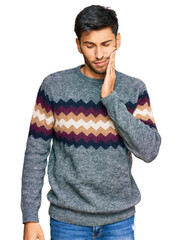 Young handsome man wearing casual winter sweater touching mouth with hand with painful expression because of toothache or dental illness on teeth. dentist