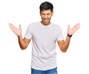 Young handsome man wearing casual white tshirt celebrating mad and crazy for success with arms raised and closed eyes screaming excited. winner concept