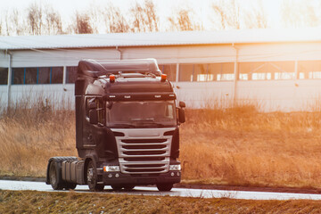 A truck travels on an open road with no trailer attached. European modern truck runs on diesel...