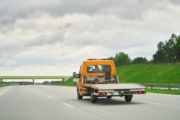 Tow Truck Transporter on the Highway. Road side assistance. A Car Carrier Tow Truck Driving Fast on...