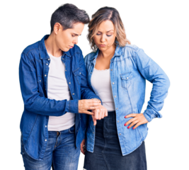 Couple of women wearing casual clothes checking the time on wrist watch, relaxed and confident
