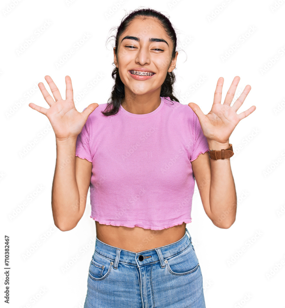 Wall mural hispanic teenager girl with dental braces wearing casual clothes celebrating crazy and amazed for su