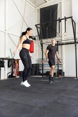 Fototapeta premium Fitness couple jumping on skipping rope in the gym