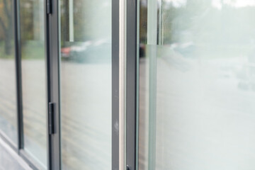 The front door of a office block, reflecting buildings in the glass