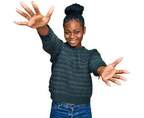 Young african american woman wearing casual clothes looking at the camera smiling with open arms for hug. cheerful expression embracing happiness. - obrazy, fototapety, plakaty