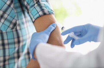 Doctor gives patient an injection in shoulder. Vaccination of population against infectious...