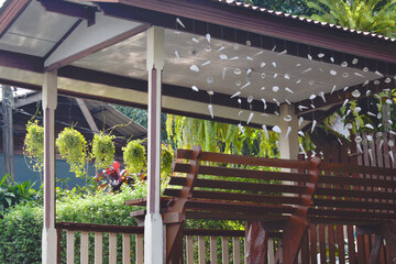 Thailand, wooden cabana overlooking the garden. Shell bells hanging from the roof