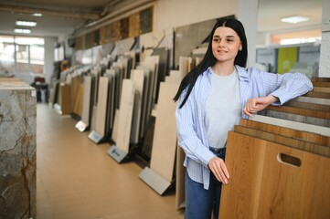 Young woman choosing laminate floor for home renovation