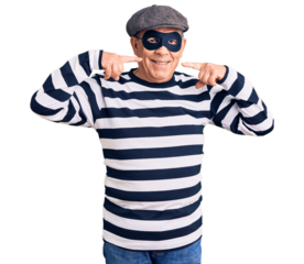 Senior handsome man wearing burglar mask and t-shirt smiling cheerful showing and pointing with fingers teeth and mouth. dental health concept.