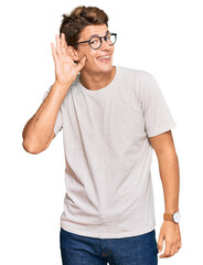 Fototapeta premium Handsome caucasian man wearing casual clothes and glasses smiling with hand over ear listening an hearing to rumor or gossip. deafness concept.