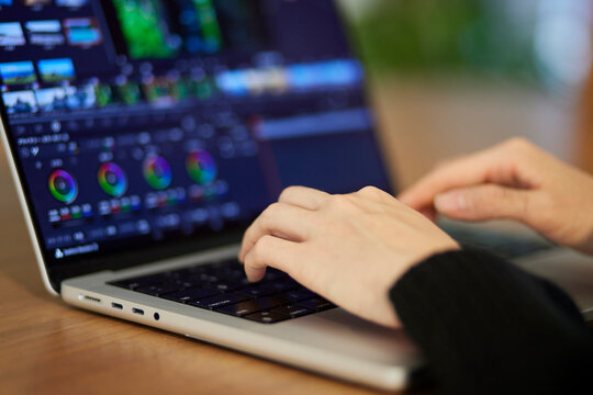 ノートパソコンにて動画編集を行うクリエイターの日本人女性