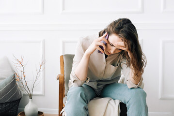 Distressed Millennial Woman on Phone, Expressing Despair While Seated, Coping with Unsettling News....