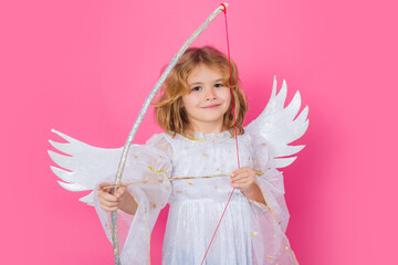 Angel kid shoots a love arrow from a bow on Valentines Day. Cute angel child, studio portrait....
