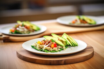 avocado slices fanned atop quinoa salad on a wooden table
