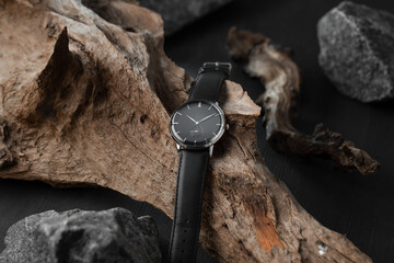 Close up of men's watch with a black strap on a wooden background.