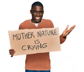 Young african american man holding mother nature is crying protest cardboard banner celebrating victory with happy smile and winner expression with raised hands